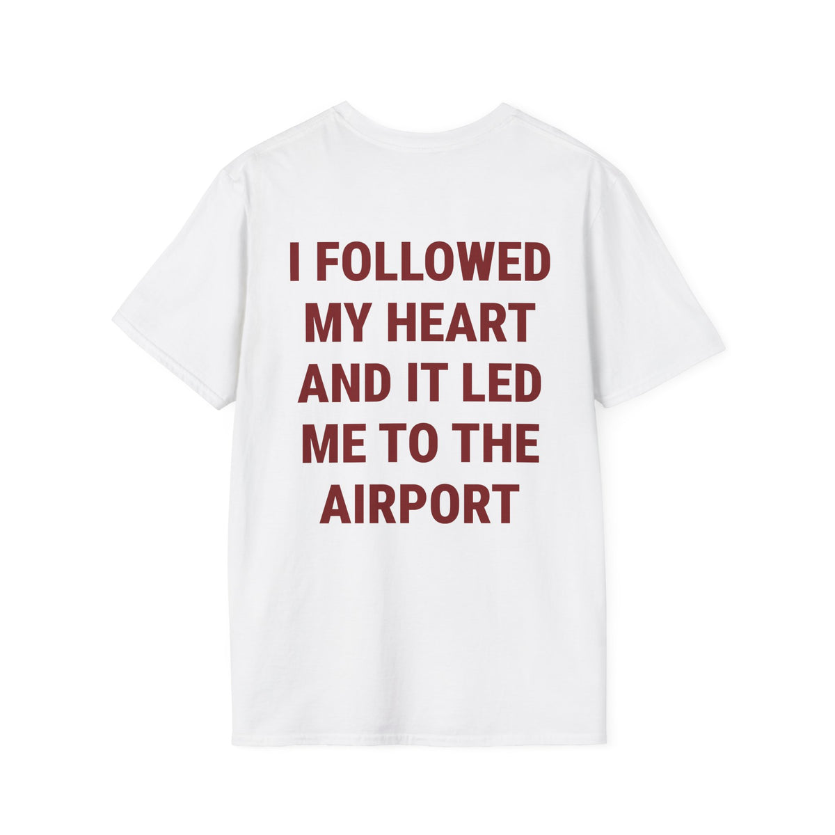 A white short-sleeve t-shirt with bold dark red text on the back that reads 'I FOLLOWED MY HEART AND IT LED ME TO THE AIRPORT', shown against a plain white background.